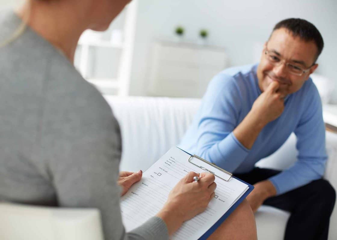 Female psychologist consulting mature man during psychological therapy session