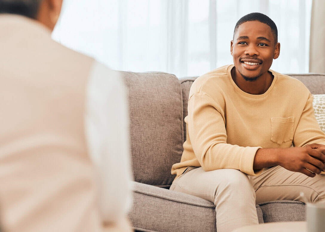 Black man, counseling and psychology consulting for therapy, mental healthcare or support. Happy patient talking to psychologist, therapist and medical help in consultation, advice and wellness check