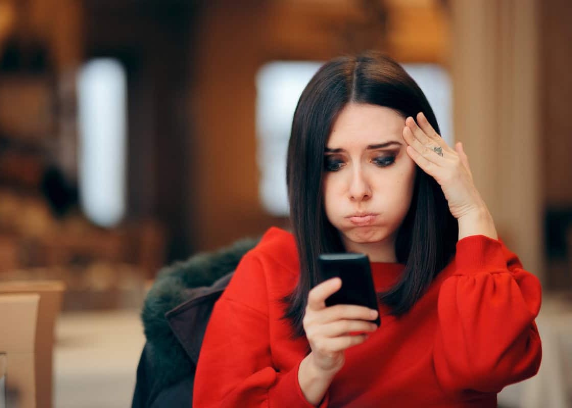 Forgetful woman receiving online notifications on her phone
