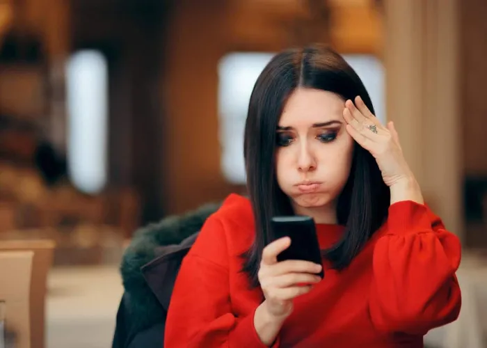 Forgetful woman receiving online notifications on her phone