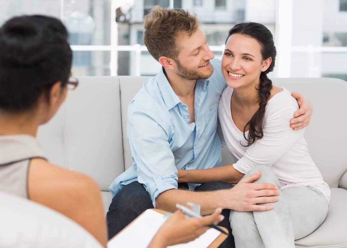 Happy couple reconciling at therapy session in therapists office