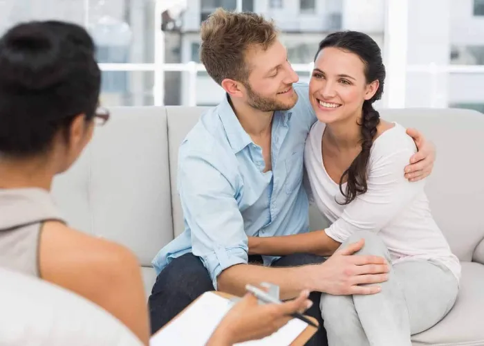 Happy couple reconciling at therapy session in therapists office