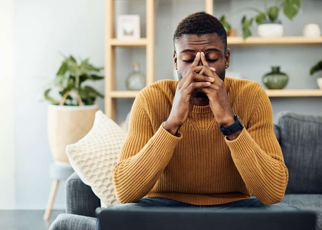 Shot of a young man looking stressed out at home